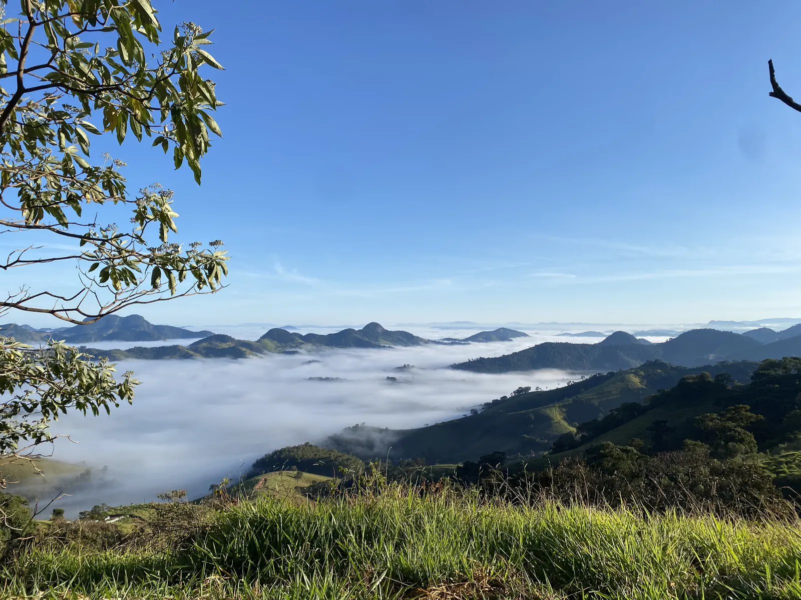 Cerca branca com mar de nuvens e céu rosado ao amanhecer