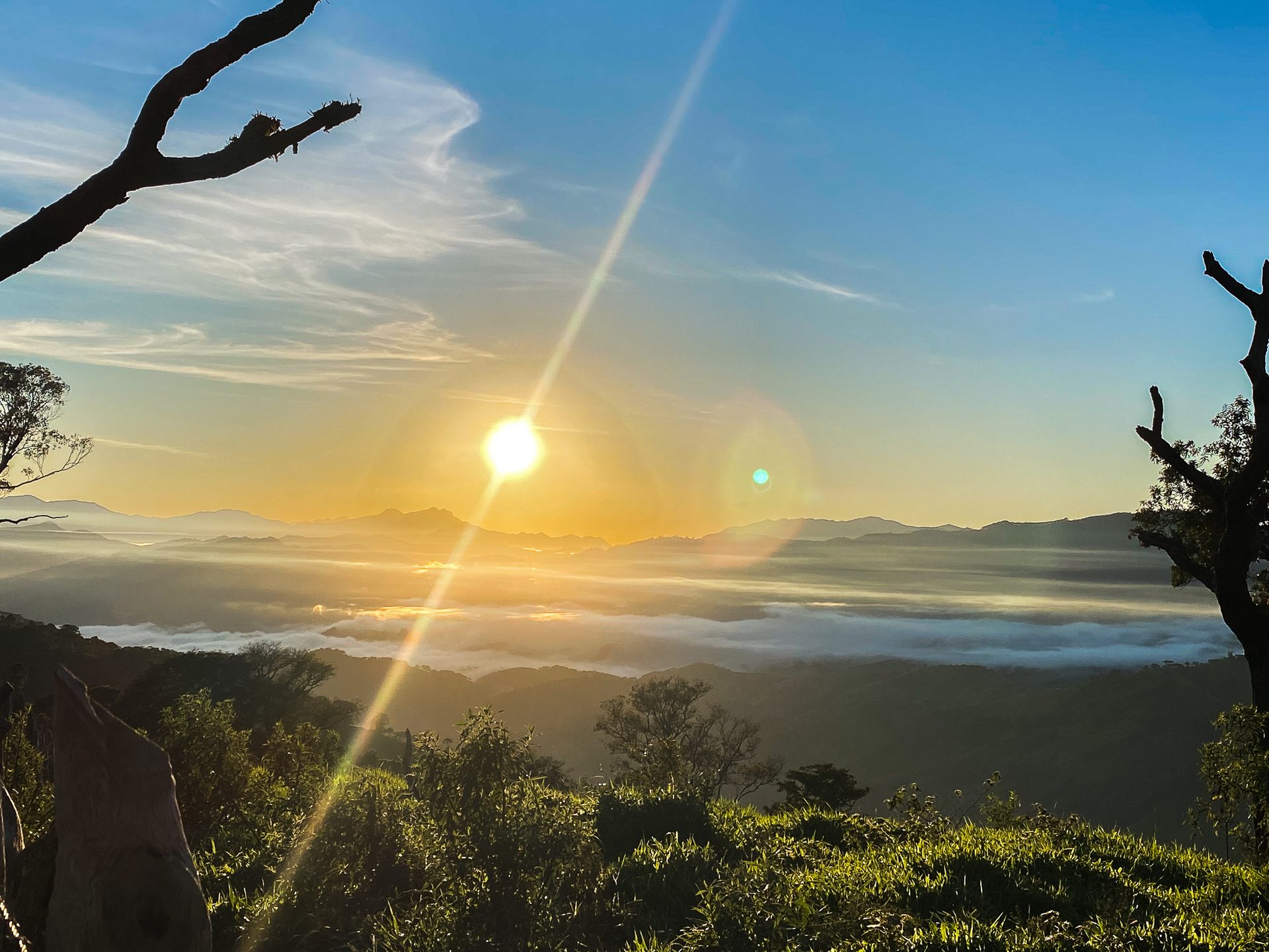 Nascer do sol com raios de luz sobre o mar de nuvens